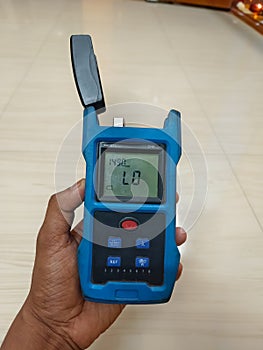 Broadband Service Technicians having Optical Power Meter. Optical fiber cable. Blue Fiber optic Machine