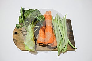 Broccoli, carrots and greenbeans on the wooden board