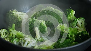 Broccoli cooking in a frying pan.