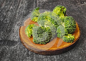 Broccoli florets on natural wooden board. Dark background. simple ingredients for health