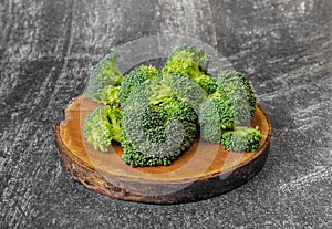 Broccoli florets on natural wooden board. Dark background. simple ingredients for health