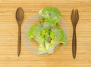 Broccoli flower and wood spoon and fork