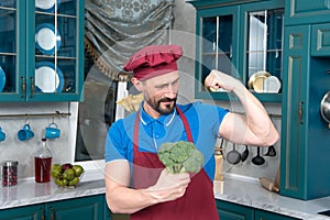 Broccoli gives power to man. bicep or broccoli chose. Guy holds broccoli in hands and shows his bicep.