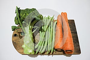 Broccoli, greenbeans and carrot on the wooden board