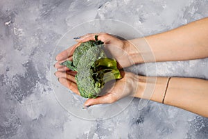 Broccoli in hands. a wooden background. healthy eating concept
