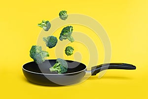 Broccoli in a pan on yellow background. Healthy concept. Copy space.