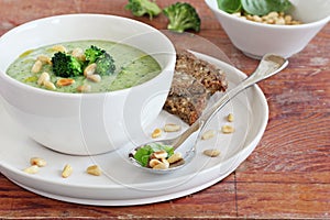 Broccoli-potato soup with pine nuts and broccoli topping