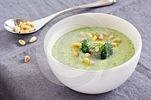 Broccoli-potato soup with pine nuts and broccoli topping