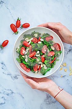 Broccoli salad with cherry tomatoes and almonds in white bowl. Vegan detox recipe