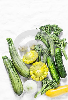 Broccoli, zucchini, squash, garlic, cucumbers - fresh organic vegetables on a light background, top view. Flat lay