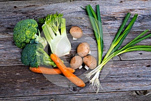 Broccolion, spring onions, fennel, mushrooms and carrots wooden on board