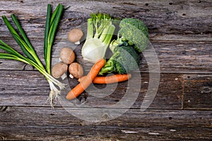 Broccolion, spring onions, fennel, mushrooms and carrots wooden on board