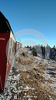 Brocken steam locomotice running up Hill winter blue sky