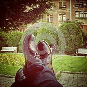 Brogue shoes resting on a luggage in park