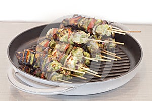 Broiled shish kabob on a stick in a skillet