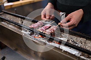 Broiling pieces of pork on charcoal fire