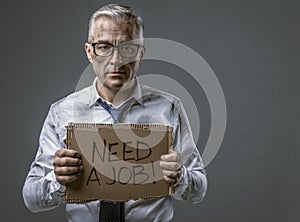 Broke jobless businessman holding a cardboard sign