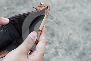 Broke man showing his brown leather wallet with no money photo