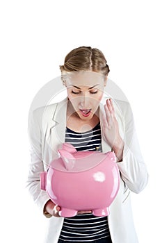 Broke woman holding a piggy bank against a white background