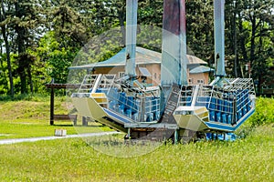 Broken abandoned carnival ride in rural park