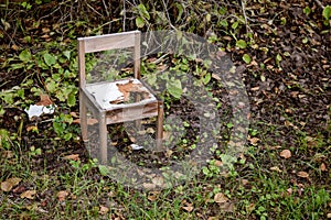 Broken and abandoned chair in the woods