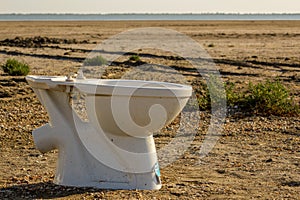 broken abandoned toilet bowl in the desert