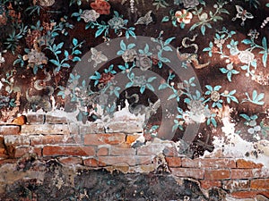 An broken ancient Thai mural painting on a decayed wall.