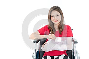 Broken arm Asian woman with arm sling sponsored in her hands sit