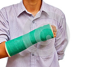 Broken arm with green cast on white background