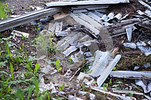 Broken asbestos cement sheets in nature, toxic waste