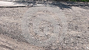 Broken automobile road with potholes and cracks.