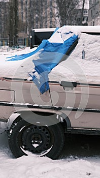 broken back windshield of a car after an accident in winter. a hole in the back windshield of a car and covered by blue