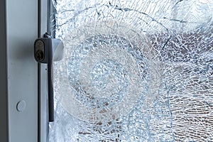 Broken balcony glass door window with shattered glass