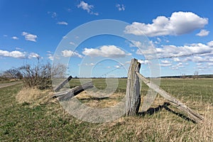 A broken barbed wire fence with old rustic wooden posts
