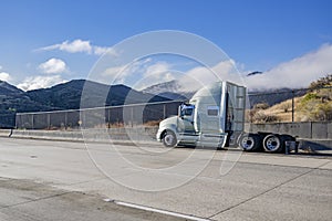 Broken big rig semi truck without of the semi trailer stands on the shoulder side of the road waiting for the mobile towing road