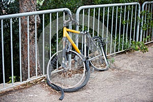Broken bike attached to a street fence