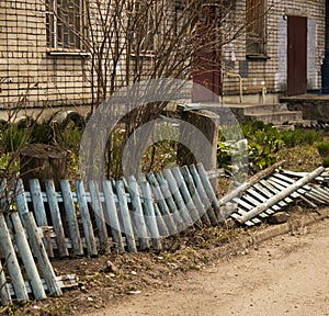 Broken blue fence front garden house in the city