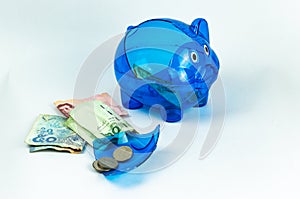 A broken blue piggy bank from a virus crisis. Money-saving plan failure signal. isolated background money and piggy bank close-up