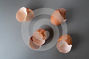 Broken brown  eggshells on gray table. Above view