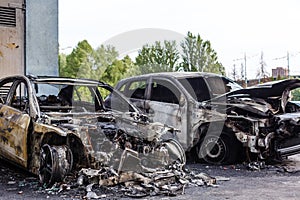 Broken and burned cars in the parking lot, accident or deliberate vandalism. Burnt car. Consequences of a car accident