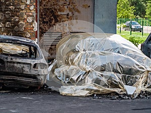 Broken and burned cars in the parking lot, accident or deliberate vandalism. Burnt car. Consequences of a car accident