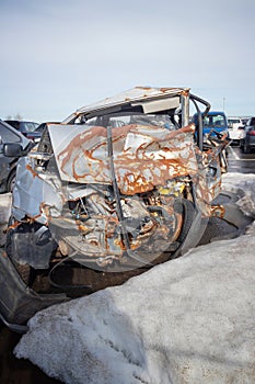 Broken and burnt cars after road accidents stand in a special parking lot