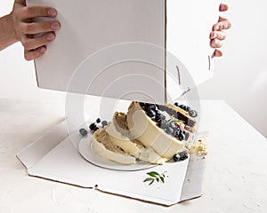 Broken cake inside the box on white background. Bad delivery concept. Spoiled birthday, wedding. Bad luck. Copy space