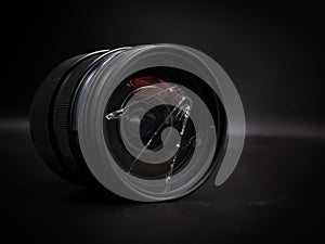 Broken camera lens in black background