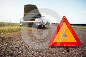 Broken car concept, breakdown triangle on road