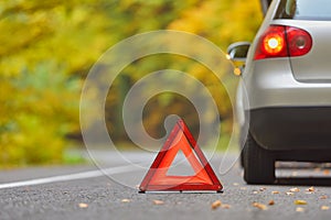 Broken car concept, breakdown triangle stop sign on road