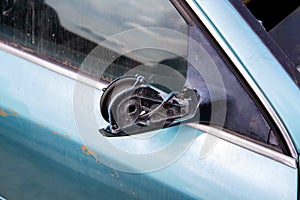 Broken car mirror on a car. Vandalism and hooliganism. Close-up photo