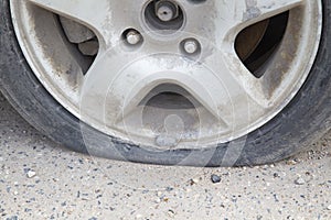 A broken car wheel. A car requiring tire repair