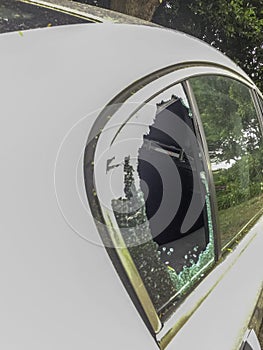 Broken car window on a white car during the day