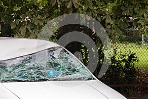 Broken car windshield after accident on road. Selective focus on white car. Car insurance concept